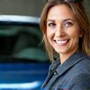 Client satisfaite devant sa voiture propre